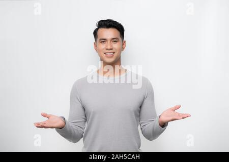 Young Asian man showing welcome sign isolé sur fond blanc. Banque D'Images