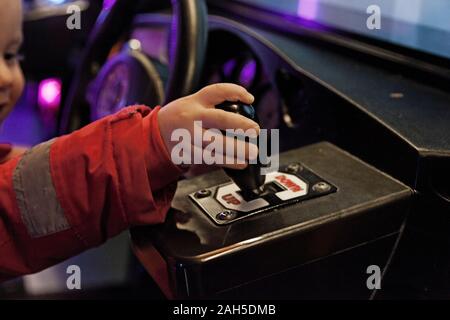 Umea, Suède Norrland - Décembre 21, 2019 : un enfant utilise le levier pour la voiture dans le jeu d'arcade Banque D'Images