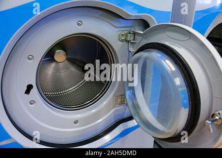Lave-linge avec porte ouverte dans la salle de lavage Banque D'Images