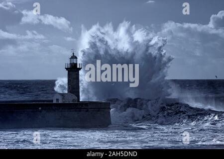 Seascape dramatique venteux. D'énormes vagues de tempête plus ancien phare splash et de la jetée. Utilisé filtre infrarouge. Banque D'Images