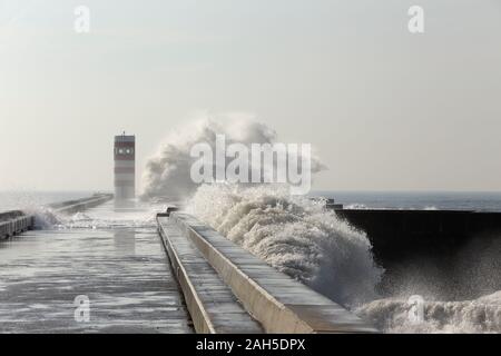 L'invasion de vagues pier avec lighthouse Banque D'Images