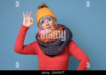 Charmante femme heureux joyeux heureux dans des vêtements d'hiver est montrant okay sign Banque D'Images