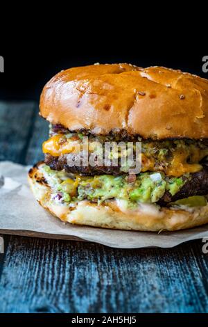 Hamburger avec sauce trempette Guacamole Guacamole / Burger. Le fast food. Banque D'Images