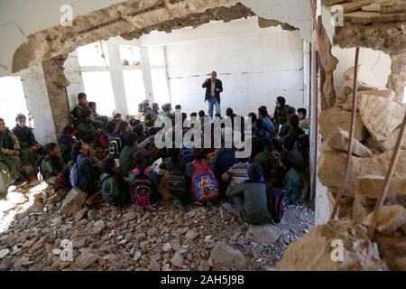 (191225) -- IBB, 25 décembre 2019 (Xinhua) -- Les élèves ont une classe dans le Shuhada-Alwahdah Al-Radhmah dans le district scolaire de la province d'Ibb, Yémen, le 23 décembre 2019. La guerre au Yémen a forcé plus de deux millions d'enfants de l'école et de mettre 3,7 millions d'autres personnes à haut risque en raison du non-paiement des salaires des enseignants, en fonction de l'Organisation des Nations Unies pour l'enfance (UNICEF). Mais pour ceux qui peuvent revenir, ils vont tout tenter pour revenir à la classe, même de s'asseoir sur les décombres d'airstrike touchés les écoles. Pour aller avec 'Caractéristique : les étudiants yéménites retour à l'airstrike-hit school' (Phot Banque D'Images