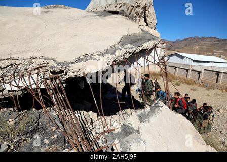 (191225) -- IBB, 25 décembre 2019 (Xinhua) -- Les élèves entrent à l'Shuhada-Alwahdah Al-Radhmah dans l'école de district de la province d'Ibb, Yémen, le 23 décembre 2019. La guerre au Yémen a forcé plus de deux millions d'enfants de l'école et de mettre 3,7 millions d'autres personnes à haut risque en raison du non-paiement des salaires des enseignants, en fonction de l'Organisation des Nations Unies pour l'enfance (UNICEF). Mais pour ceux qui peuvent revenir, ils vont tout tenter pour revenir à la classe, même de s'asseoir sur les décombres d'airstrike touchés les écoles. Pour aller avec 'Caractéristique : les étudiants yéménites retour à l'airstrike-hit school' (photo de Moham Banque D'Images