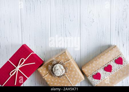 Trois cadeaux close up sur un fond en bois clair avec une place pour copier l'espace. Pour le texte du châssis avec des boîtes de cadeaux. Banque D'Images