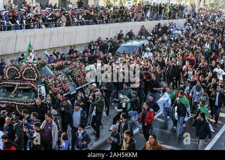 Alger, Algérie. Dec 25, 2019. Les gens se rassemblent autour d'un véhicule blindé, tirant le cercueil recouvert du drapeau du chef de l'état-major de l'armée algérienne Ahmed Gaid Salah, lors de ses funérailles, après qu'il est mort à l'âge de 79 ans suite à une crise cardiaque. Salah, l'un des principaux acteurs dans une année difficile pour l'Algérie, a été considéré comme déterminant dans la démission du président Abdelaziz Bouteflika en avril, ajoutant à la pression sur la barre après des protestations de masse dans le pays. Credit : Farouk Batiche/dpa/Alamy Live News Banque D'Images