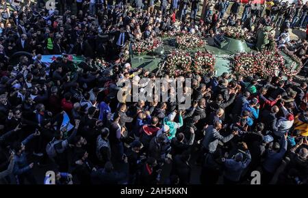 Alger, Algérie. Dec 25, 2019. Les gens se rassemblent autour d'un véhicule blindé, tirant le cercueil recouvert du drapeau du chef de l'état-major de l'armée algérienne Ahmed Gaid Salah, lors de ses funérailles, après qu'il est mort à l'âge de 79 ans suite à une crise cardiaque. Salah, l'un des principaux acteurs dans une année difficile pour l'Algérie, a été considéré comme déterminant dans la démission du président Abdelaziz Bouteflika en avril, ajoutant à la pression sur la barre après des protestations de masse dans le pays. Credit : Farouk Batiche/dpa/Alamy Live News Banque D'Images