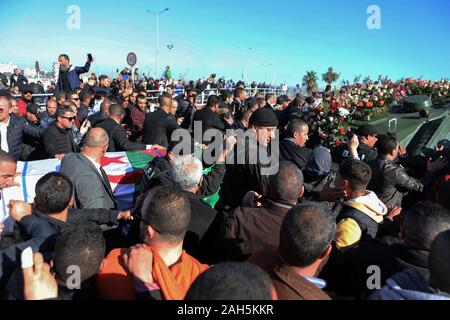 Alger, Algérie. Dec 25, 2019. Les gens se rassemblent autour d'un véhicule blindé, tirant le cercueil recouvert du drapeau du chef de l'état-major de l'armée algérienne Ahmed Gaid Salah, lors de ses funérailles, après qu'il est mort à l'âge de 79 ans suite à une crise cardiaque. Salah, l'un des principaux acteurs dans une année difficile pour l'Algérie, a été considéré comme déterminant dans la démission du président Abdelaziz Bouteflika en avril, ajoutant à la pression sur la barre après des protestations de masse dans le pays. Credit : Farouk Batiche/dpa/Alamy Live News Banque D'Images