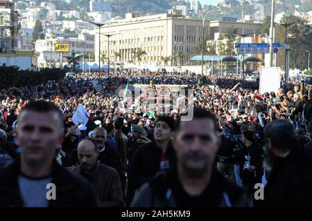 Alger, Algérie. Dec 25, 2019. Les gens se rassemblent autour d'un véhicule blindé, tirant le cercueil de chef d'état-major de l'armée algérienne Ahmed Gaid Salah, lors de ses funérailles, après qu'il est mort à l'âge de 79 ans suite à une crise cardiaque. Salah, l'un des principaux acteurs dans une année difficile pour l'Algérie, a été considéré comme déterminant dans la démission du président Abdelaziz Bouteflika en avril, ajoutant à la pression sur la barre après des protestations de masse dans le pays. Credit : Farouk Batiche/dpa/Alamy Live News Banque D'Images