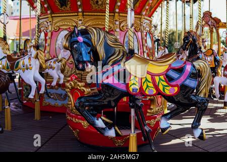 Carrousel pour les enfants avec des chevaux dans le parc attractions Banque D'Images