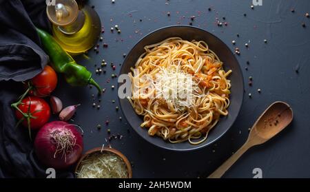 Les nouilles, les pâtes à la sauce tomate maison, les ingrédients pour faire revenir la tomate, rustique, l'arrière-plan zenith verticale Banque D'Images