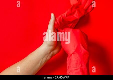 Les mains des hommes porter des gants en caoutchouc rouge avant de commencer à travailler Banque D'Images