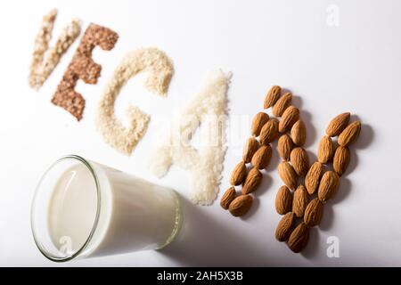 Mot vegan faites de grains entiers et les noix et le lait dans un verre sur un fond blanc Banque D'Images