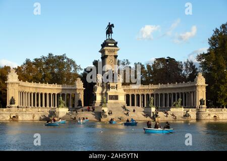 MADRID, ESPAGNE - Décembre, 2019 : aux personnes bénéficiant d'une heure sur la ligne Piscine bateaux autour de monument à Alfonso XII à Retiro Park sur un après-midi ensoleillé Banque D'Images