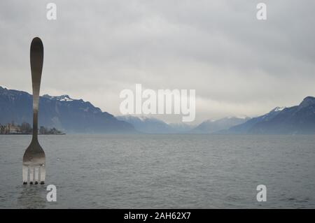 Vevey, Suisse. 20 décembre 2019. Vue sur le lac Léman à Vevey avec une sculpture à fourche en acier inoxydable géant au lac Léman. Banque D'Images