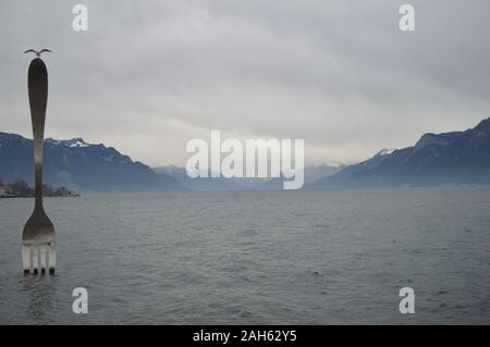 Vevey, Suisse. 20 décembre 2019. Vue sur le lac Léman à Vevey avec une sculpture à fourche en acier inoxydable géant au lac Léman. Banque D'Images