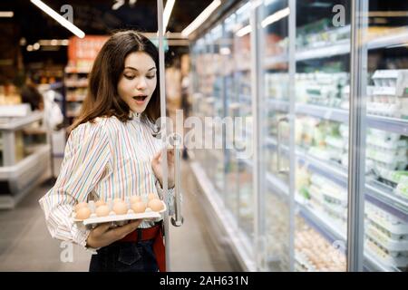 Très jolie fille, c'est shopping dans un grand magasin. La jeune fille achète des courses au supermarché. Banque D'Images