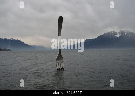 Vevey, Suisse. 20 décembre 2019. Vue sur le lac Léman à Vevey avec une sculpture à fourche en acier inoxydable géant au lac Léman. Banque D'Images