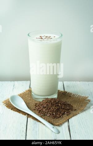 Verre de kéfir avec graines de lin hachées, sur blanc. Concept de boissons pour perte de poids, régime alimentaire. Banque D'Images