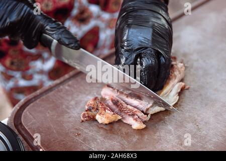 Mains Chef slicing steak juteux avec un couteau. Banque D'Images