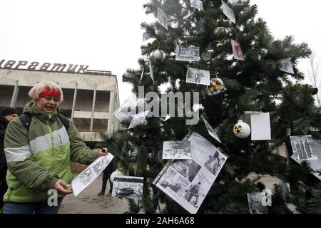 Kiev, Ukraine. Dec 25, 2019. Les anciens résidents de Pripyat décorer avec leurs photos d'un arbre de Noël installé sur une place centrale de la ville abandonnée Pripyat, environ 3 km de la centrale nucléaire de Tchernobyl, l'Ukraine, le 25 décembre 2019.Les anciens habitants de Pripyat, certains n'ont pas voir leur ville pour plus de 33 ans, venaient de Slavutych à Pripyat pour décorer l'arbre de Noël avec des photos de famille prises dans Pripyat avant expulsion. L'action visant à attirer l'attention sur la préservation de la ville de Pripyat et d'autres structures et des objets de la zone d'exclusion de Tchernobyl. L'Chernoby Banque D'Images