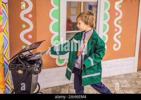 Peu cute boy throwing paper dans la corbeille Banque D'Images