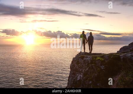 Couple aventureux et debout sur une falaise rocheuse Banque D'Images