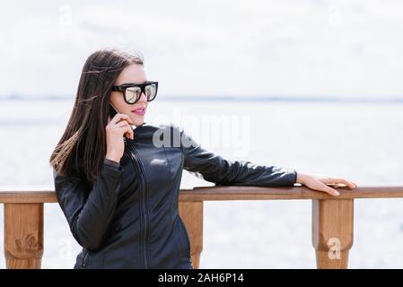 La jeune fille parle au téléphone dans la nature Banque D'Images