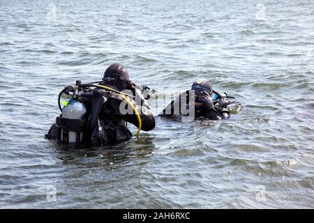 Deux plongeurs dans l'équipement de plongée complet prêt à aller sous l'eau Banque D'Images