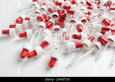 Pipettes transparent avec un soufflet rouge sur fond blanc Banque D'Images