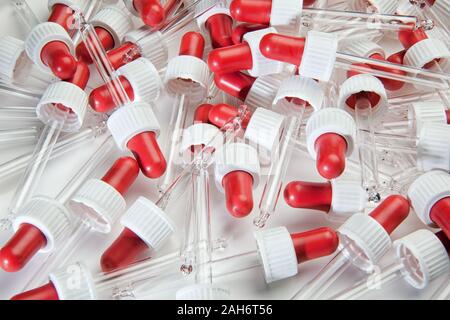 Pipettes transparent avec un soufflet rouge sur fond blanc Banque D'Images