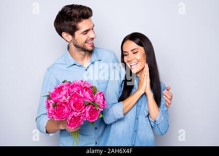 Photo de belle belle cute couple de deux personnes amie se réjouir avec la réception de bouquet de fleurs fuchsia et son petit ami en l'embrassant, de l'arrière Banque D'Images