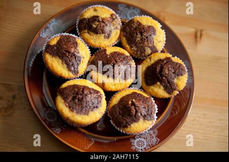 Des muffins au chocolat citron, peu de duo le goût délicieux cupcakes couché sur plaque brun foncé sur table, friandises Vue de dessus, au four de la nourriture. Banque D'Images