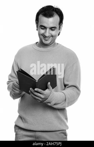 Studio shot of Persian man smiling and reading book Banque D'Images