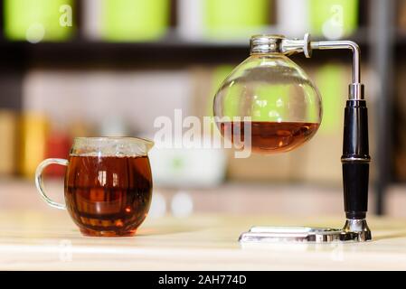 Infuseur à thé avec une tasse sur la table Banque D'Images