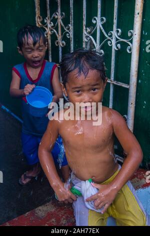 Un enfant joue avec l'eau pendant le festival de Higantes à Angono Philippines Banque D'Images