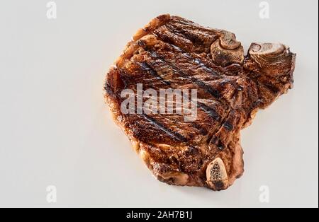 Ou grillé mariné au barbecue steak cowboy, ou en os ribeye, isolé sur un fond blanc dans un high angle view with copy space Banque D'Images