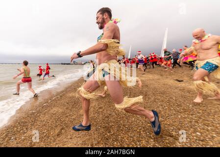 Plage du Jubilé, Marine Parade, Southend on Sea, Essex, Royaume-Uni. Comme c'est devenu une tradition dans la région de seaside endroits, un 'Boxing Day' Dip a eu lieu dans le froid, rugueux Thames Estuary à Southend collecter des fonds pour la RNLI. La plupart des nageurs portaient des habits de fête, courageux Banque D'Images