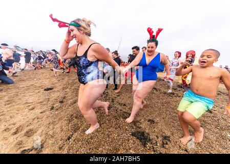 Plage du Jubilé, Marine Parade, Southend on Sea, Essex, Royaume-Uni. Comme c'est devenu une tradition dans la région de seaside endroits, un 'Boxing Day' Dip a eu lieu dans le froid, rugueux Thames Estuary à Southend collecter des fonds pour la RNLI. La plupart des nageurs portaient des habits de fête, courageux Banque D'Images