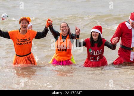 Plage du Jubilé, Marine Parade, Southend on Sea, Essex, Royaume-Uni. Comme c'est devenu une tradition dans la région de seaside endroits, un 'Boxing Day' Dip a eu lieu dans le froid, rugueux Thames Estuary à Southend collecter des fonds pour la RNLI. La plupart des nageurs portaient des habits de fête, courageux Banque D'Images