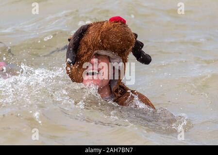 Plage du Jubilé, Marine Parade, Southend on Sea, Essex, Royaume-Uni. Comme c'est devenu une tradition dans la région de seaside endroits, un 'Boxing Day' Dip a eu lieu dans le froid, rugueux Thames Estuary à Southend collecter des fonds pour la RNLI. La plupart des nageurs portaient des habits de fête, courageux Banque D'Images