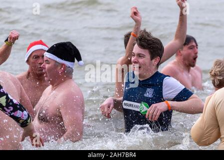 Plage du Jubilé, Marine Parade, Southend on Sea, Essex, Royaume-Uni. Comme c'est devenu une tradition dans la région de seaside endroits, un 'Boxing Day' Dip a eu lieu dans le froid, rugueux Thames Estuary à Southend collecter des fonds pour la RNLI. La plupart des nageurs portaient des habits de fête, courageux Banque D'Images