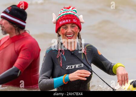 Plage du Jubilé, Marine Parade, Southend on Sea, Essex, Royaume-Uni. Comme c'est devenu une tradition dans la région de seaside endroits, un 'Boxing Day' Dip a eu lieu dans le froid, rugueux Thames Estuary à Southend collecter des fonds pour la RNLI. La plupart des nageurs portaient des habits de fête, courageux Banque D'Images