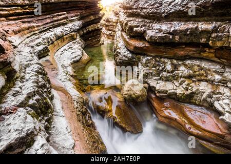 Vue panoramique d'un canyon en grès rouge avec un ruisseau qui s'étend sur son fond Banque D'Images