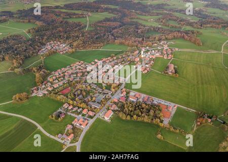 Vue aérienne de la petite ville avec leur toit de tuiles rouges parmi les champs et vert forêt lointaine en été. Banque D'Images