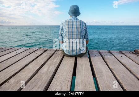 Mer Man relaxing on pier Banque D'Images