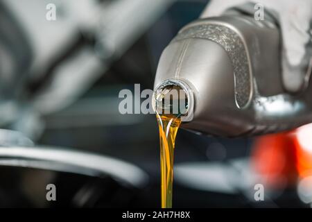 Vue partielle de l'huile de moteur mécanicien pouring bottle Banque D'Images