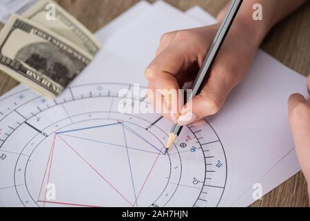 Portrait de l'astrologue dimensions carte de naissance à côté de l'argent sur la table Banque D'Images