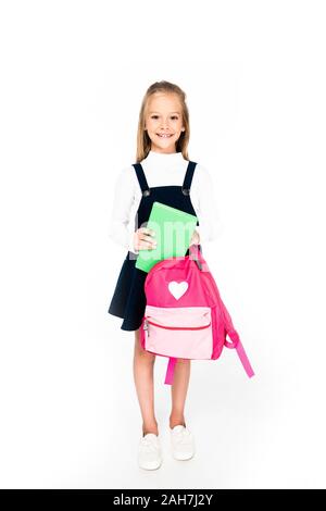 Sur toute la longueur de la tenue d'écolière mignon sac à dos et livre sur fond blanc Banque D'Images